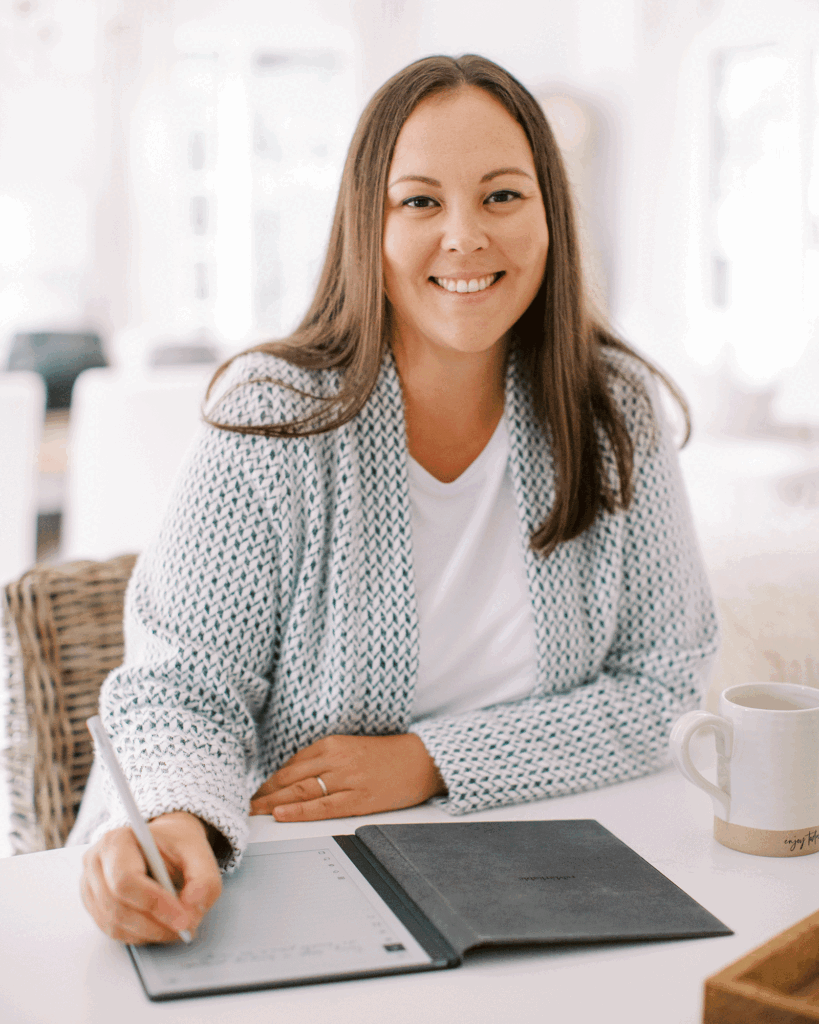 Editor, Lisa Frenette, sitting at a desk and writing in a notebook